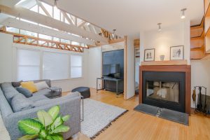 A living room with a couch facing a fireplace