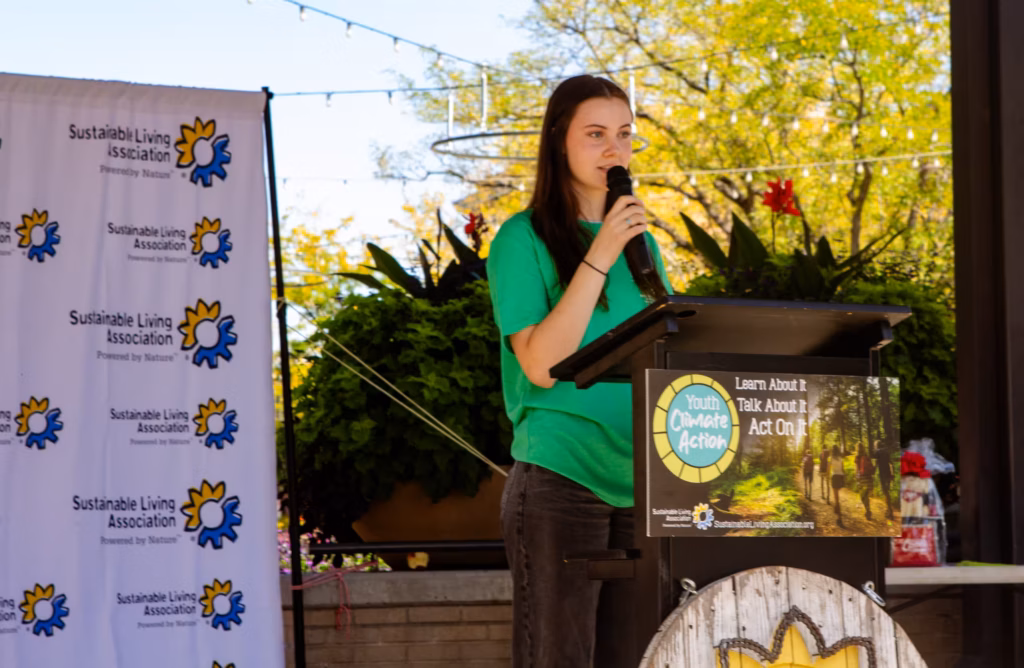 A female youth giving a speech on stage at the Youth Climate Action event.