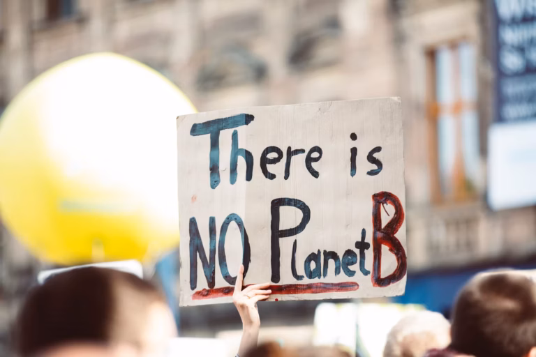 A hand holding a sign that says, "There is NO Planet B"